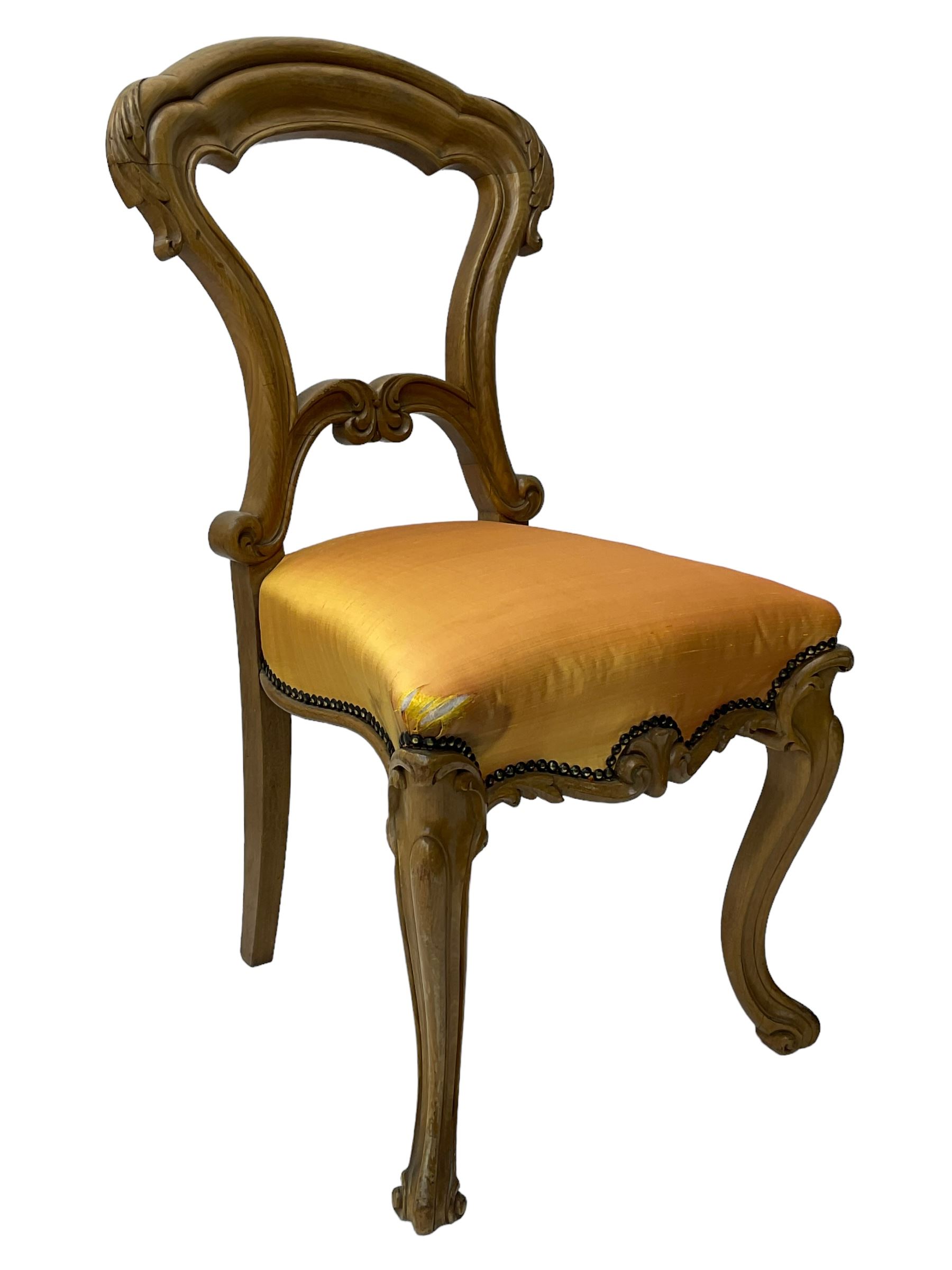 Pair of Victorian walnut side chairs, shaped cresting rail carved with acanthus leaves, overstuffed upholstered seats with stud band, on cabriole supports with scroll carved terminals