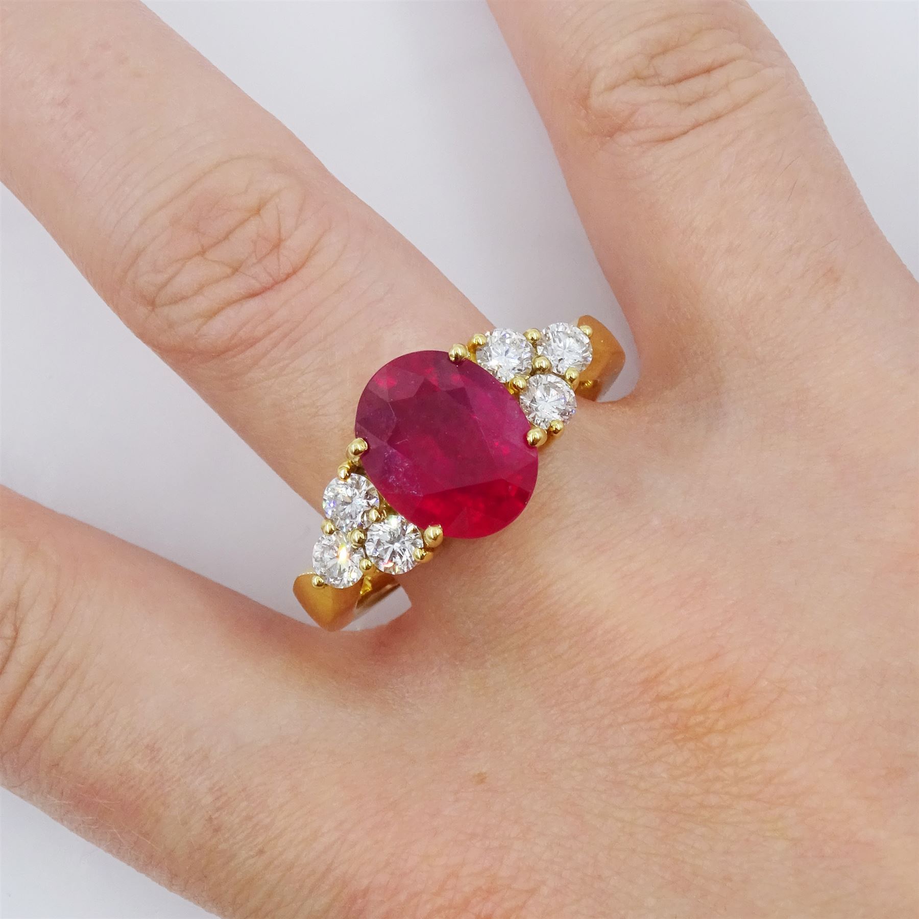 18ct gold ruby and diamond ring, single oval cut ruby of approx 5.35 carat, with three round brilliant cut diamonds set either side, stamped, total diamond weight approx 1.00 carat
