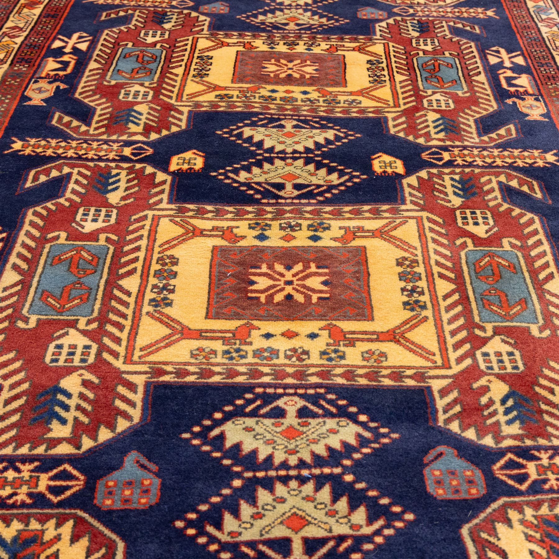North West Persian Ardebil hand-knotted runner, indigo blue field composed of a repeating series of large stepped octagonal medallions enclosing a central hooked motif and stylized rosette, flanked by angular ivory and madder red latch hook devices, medallions linked by smaller geometric diamonds and serrated lozenges, guard borders with reciprocal motifs and main ivory border decorated with angular vines, with cotton fringe ends 
