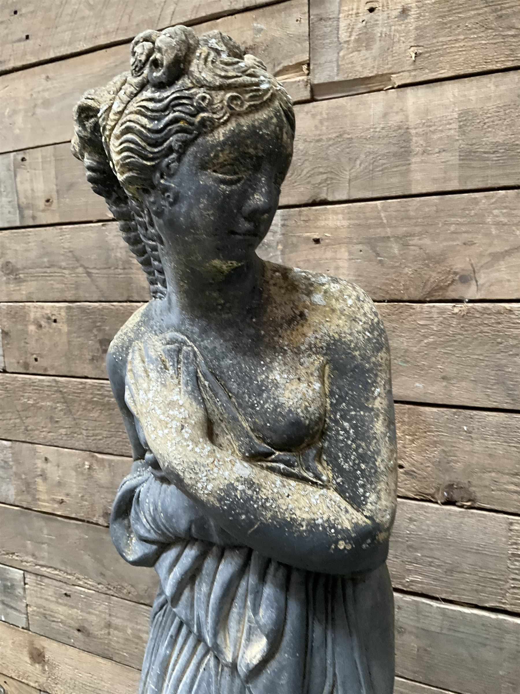 Cast stone weathered garden statue of Venus on pedestal
