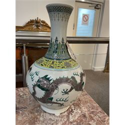 Pair 20th century Chinese famille verte bottle vases, each decorated with green and purple dragons chasing pearls amidst auspicious flames, the neck with yellow and green stylised foliate and cell borders, and the white glazed body incised throughout with fan shapes, each with red character mark beneath flanked by green dragons, H38cm

