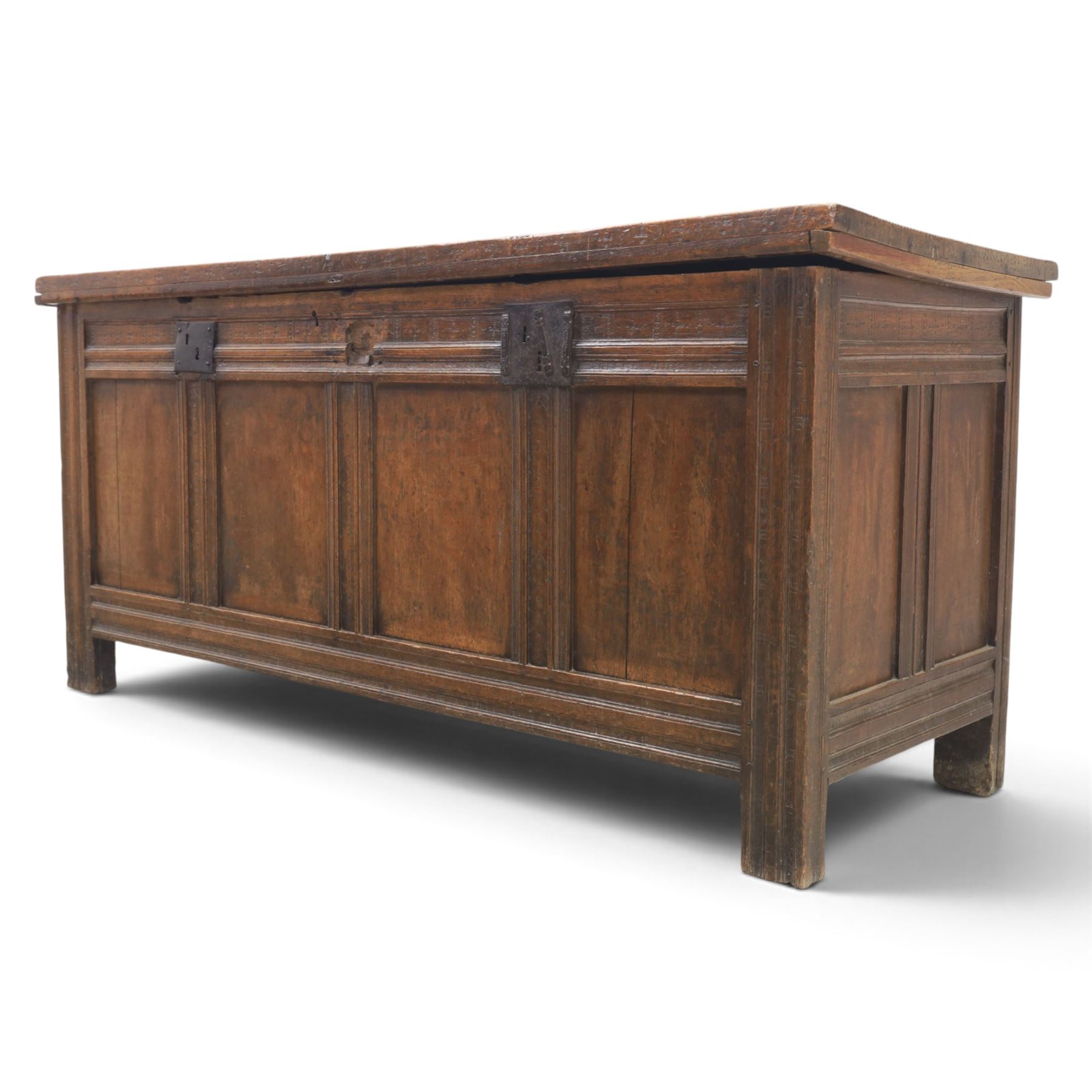 Large 17th century oak coffer, plank top with moulded edge, four panel front with channel moulded uprights, retaining original wrought iron strap hinges and central lock plate, panelled ends, raised on stile supports