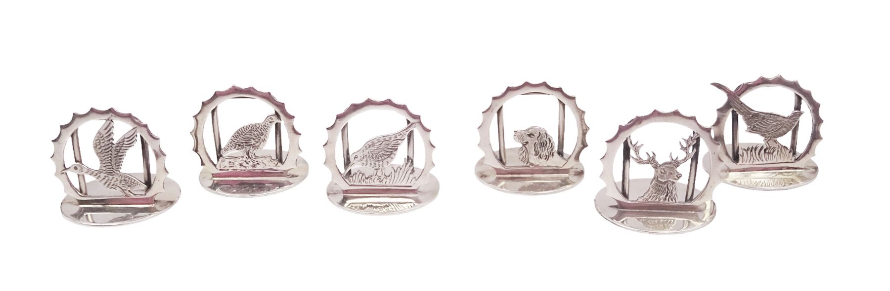 Set of six modern silver place card holders, each of circular form with pierced depictions of a partridge, spaniel, pheasant, stag, woodcock and duck, hallmarked J A Campbell, London 1985, contained within a velvet and silk lined fitted case, H3cm