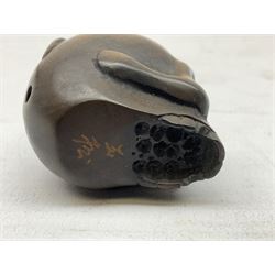 Netsuke in the form of a rat sitting on a skull, signed to the base