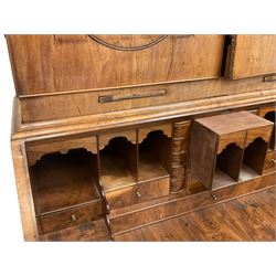 18th century walnut bookcase on bureau, the bookcase with sloped top pediment over two panelled doors and candle slides, fitted with two adjustable shelves and pigeon holes, the bureau with fall front enclosing a well fitted interior, with a combination of pigeon holes, drawers and secret compartments, fitted with two small and four long graduating drawers, on bracket feet