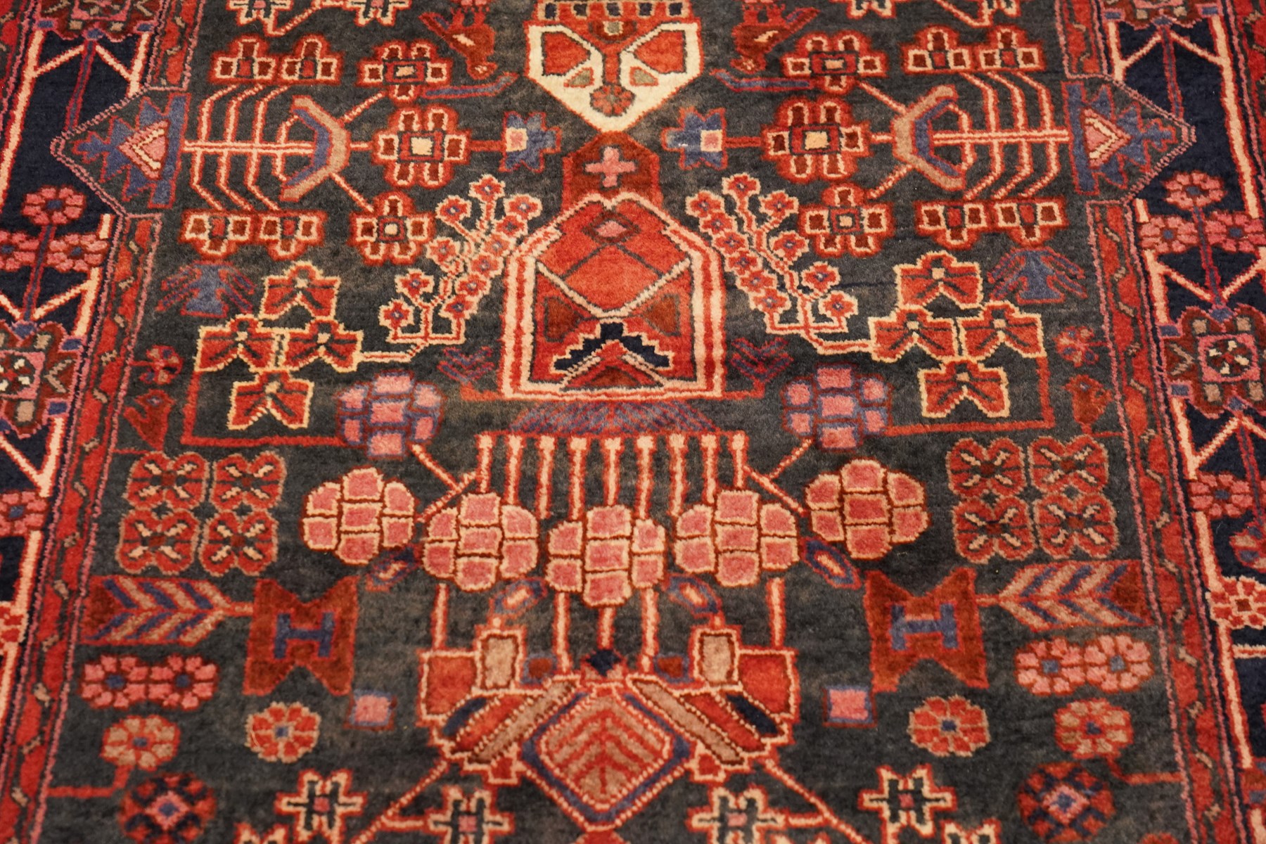 Persian Hamadan runner rug, the indigo ground decorated with stylised flowering plants and geometric motifs in crimson, rose and ivory, enclosed by an indigo flowerhead border and narrow red guard stripes