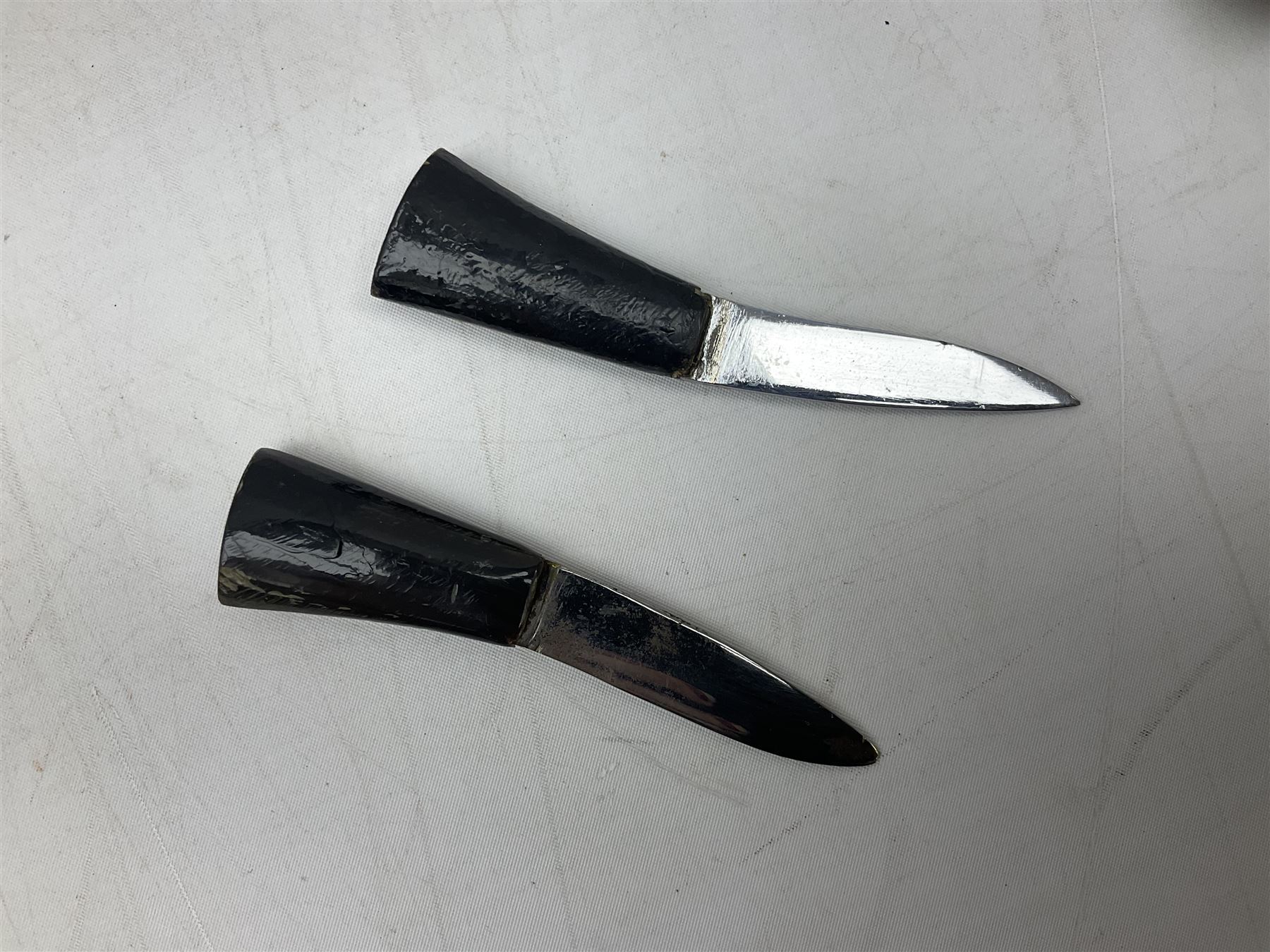 Ceremonial kukri, the 28.5cm curving blade inscribed 'O RDEP NEPAL 9/81' with brass mounted horn grip; in gloss black scabbard with two skinning knives 41cm overall