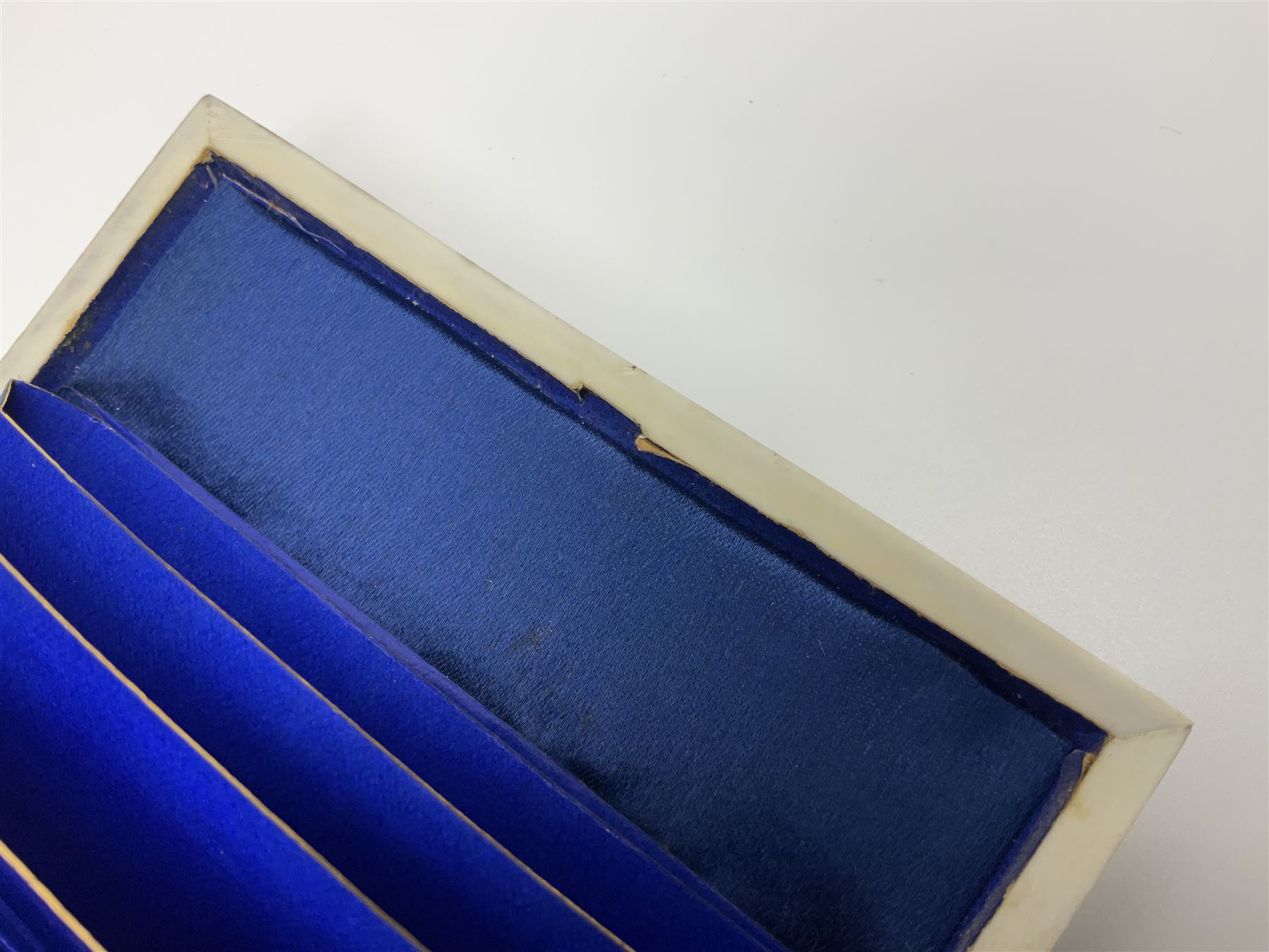 Victorian mother of pearl tea caddy, of rectangular bow-fronted form, the body with floral, bird and geometric engraved mother of pearl panels, white metal shield plaque to the cover inscribed with the initials G.J.A and similar escutcheon, the two division interior with ivory edging and two panelled mother of pearl lids, on four vegetable ivory bun feet L20cm, together with a similar style mother of pearl card case (2) This item has been registered for sale under Section 10 of the APHA Ivory Act