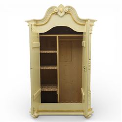 20th century French white and parcel gilt painted armoire, the shaped and scroll moulded cornice centred with a stylised foliate, the double doors with raised panel reserves applied with gilt foliate scrollwork, flanked by fluted pilasters with floral capitals, opening to a fitted interior with shelving and hanging space, raised on a moulded plinth on squat bun feet