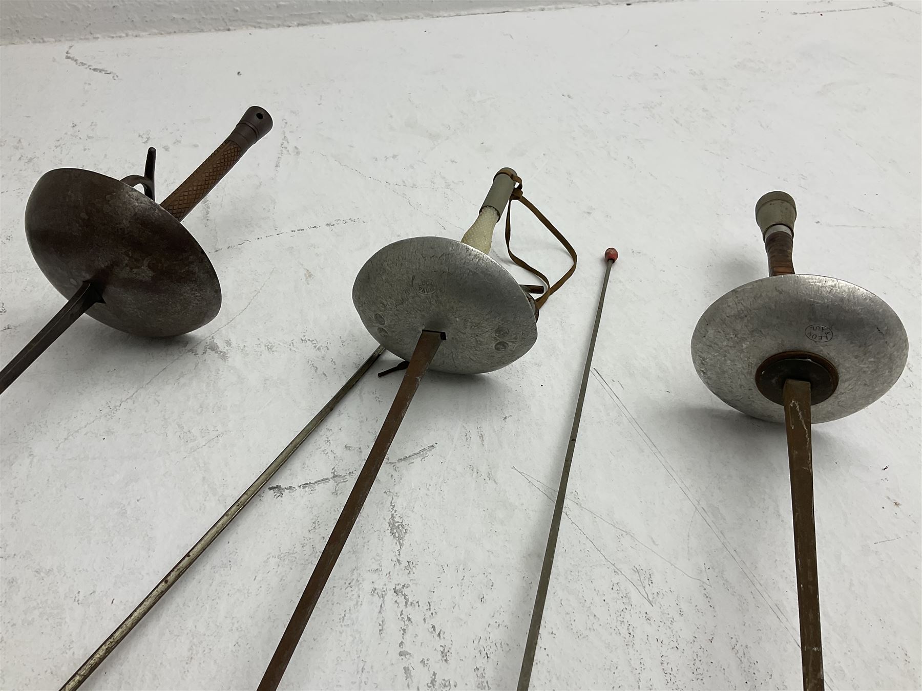 20th century Indian Tulwar sword with 71cm plain curving steel blade and iron hilt with extended langets, knopped grip and spiked pommel; in canvas covered wooden scabbard L87.5cm overall; together with five fencing swords comprising four foils and one epee, three marked Leon Paul, one in carrying case (6)