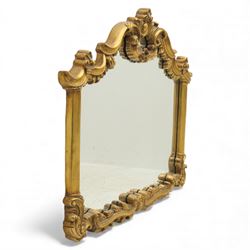 Late 20th century giltwood and composition over mantel mirror, with shaped and scrolled cresting centred by a shell cartouche, with foliate moulded shoulders and lower rail framing a rectangular plate