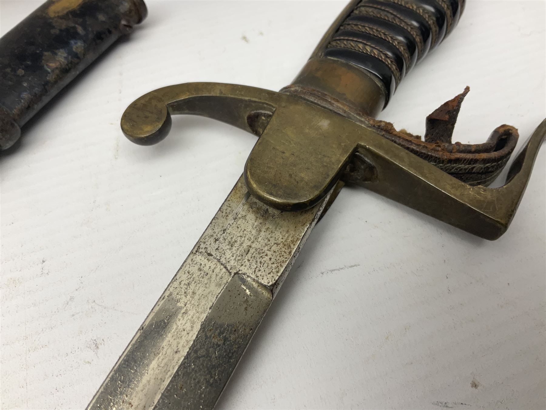 Prussian artillery officer's sword, with 80cm slightly curving fullered  blade, brass hilt with D-shaped langets, curving knucklebow, wire-bound black grip and leather finger loop; in black painted steel scabbard with single suspension loop