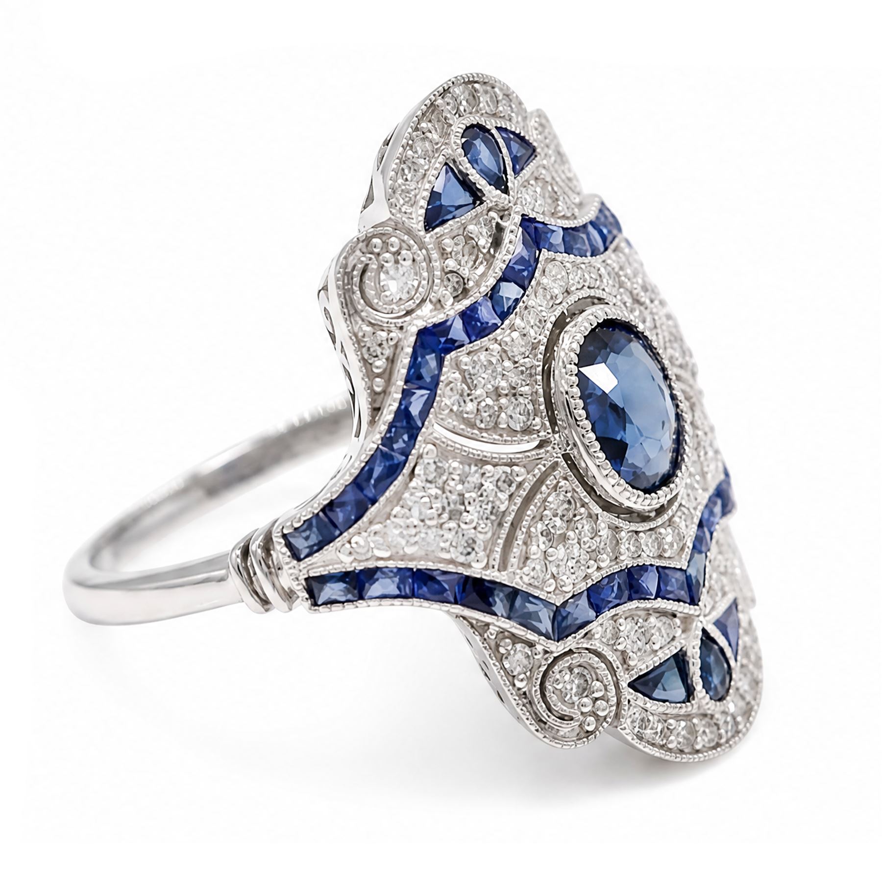 Platinum sapphire and diamond dress ring, milgrain set with a single oval cut sapphire, surrounded by single cut diamonds, calibre and vari-cut sapphires, in an pierced design setting, stamped PT 950, total sapphire weight 0.87 carat, total diamond weight 0.45 carat