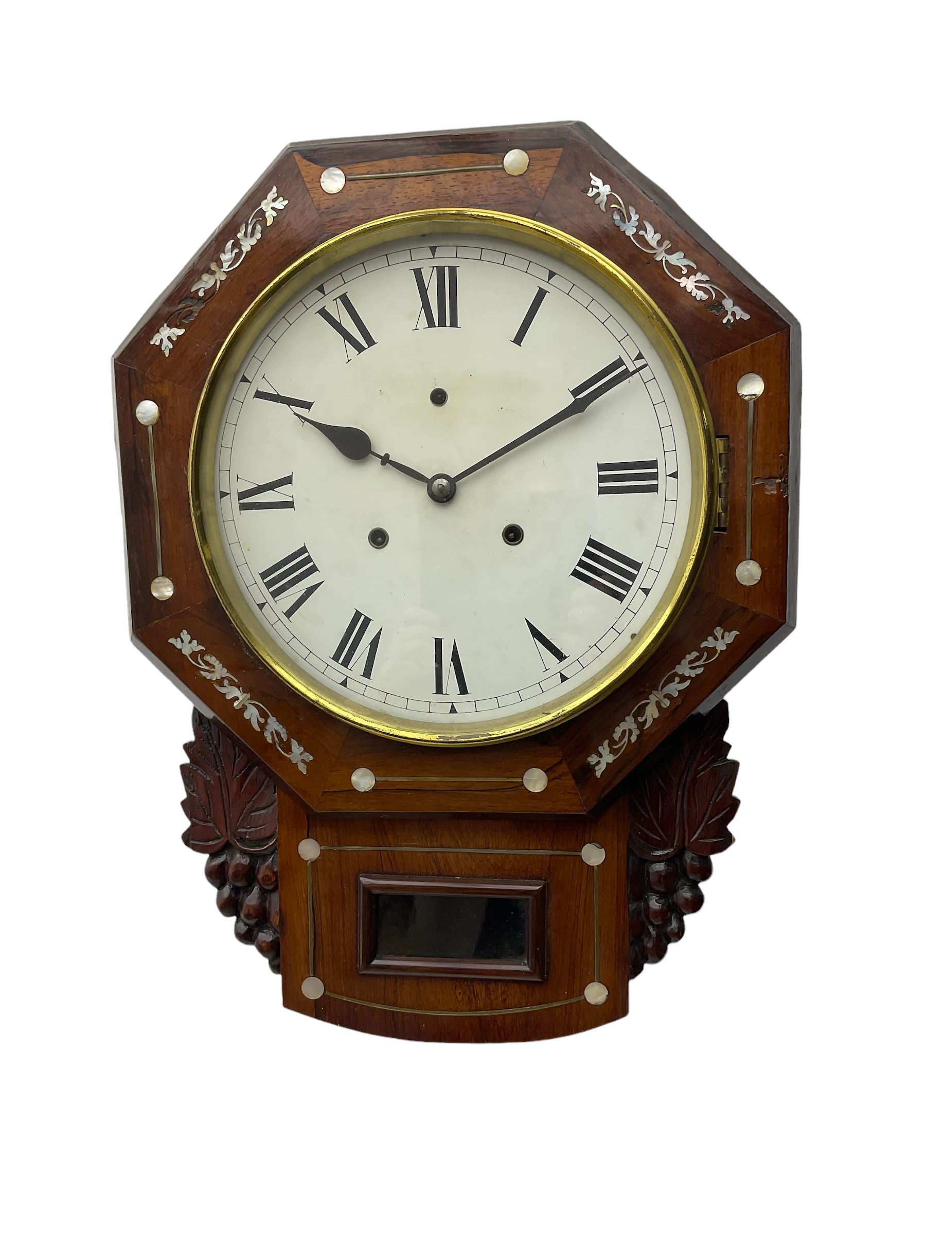 American - late 19th century 8-day mahogany drop dial wall clock, with a hexagonal dial bezel inlaid with mother of pearl, pendulum box with a rectangular viewing glass flanked by carved representations of grape vines, with a painted dial with roman numerals, minute track and steel spade hands within a spun brass bezel, eight day striking movement striking the hours on a gong.   With pendulum & key.