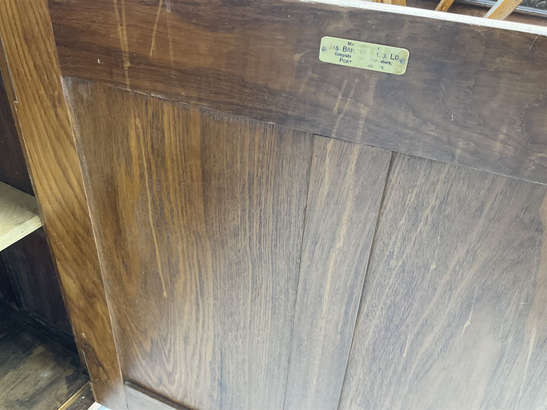 JAS Brister & Co Ld - Mid-20th century teak sideboard, fitted with two drawers over two panelled cupboards, stamped 'JAS. Brister & Co Ltd., Complete House Furniture, Port Elizabeth'