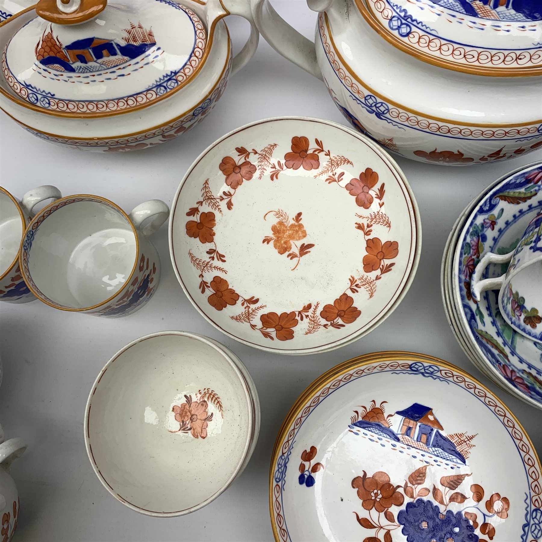 Early 19th century Spode Dolls House pattern tea wares, comprising teapot, twin handled sucrier and cover, milk jug, five teacups, two coffee cans, six saucers, stand, and shallow dish, decorated with a house and flowers in blue and orange, a number of pieces marked with pattern number 488, together with a quantity of other 19th century tea wares. 