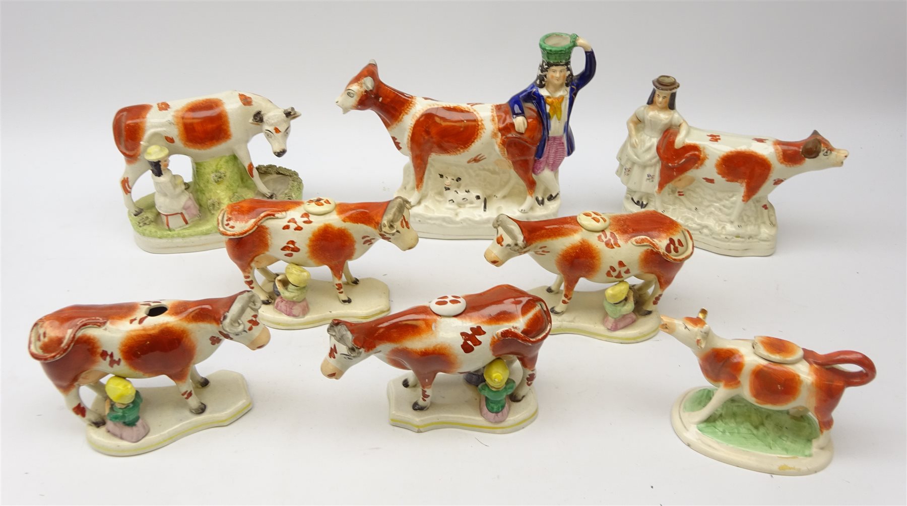 Five 19th century Staffordshire Cow Creamers on shaped bases with