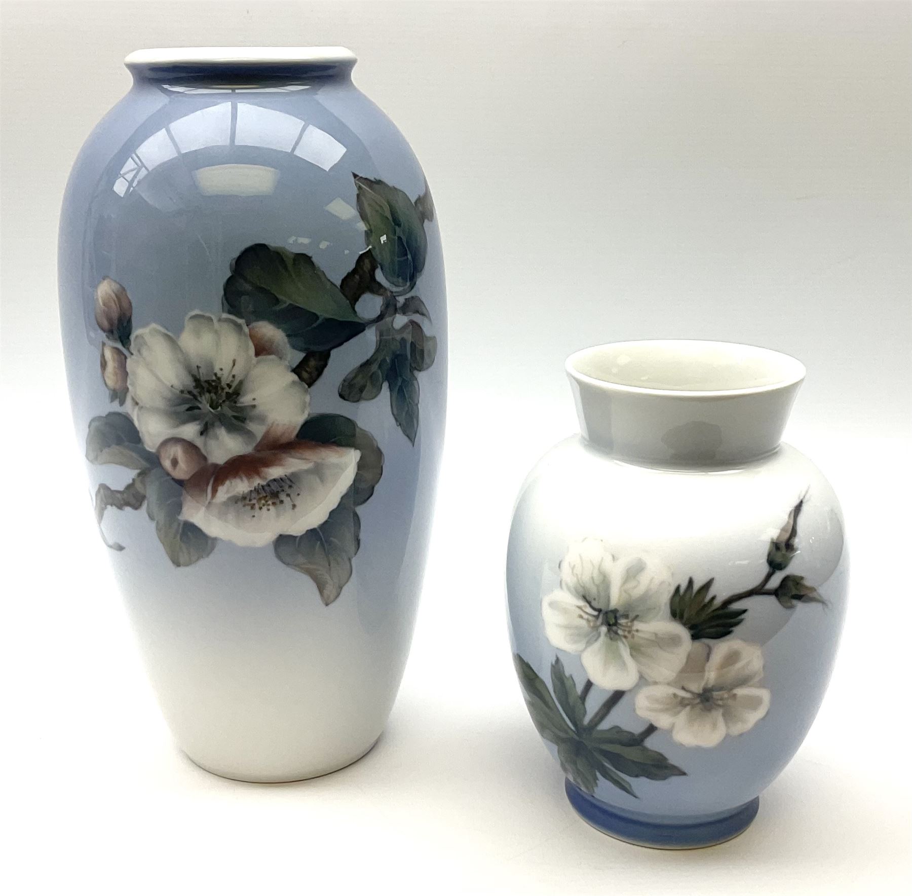 Two Royal Copenhagen vases, first example a vase of baluster form with apple blossom design on a pale blue ground, model no 2629 design no 2129 H27.5cm, second example a vase of ovoid form, with flower and butterfly decoration, model no 2667 design no 36 H17.5cm. 