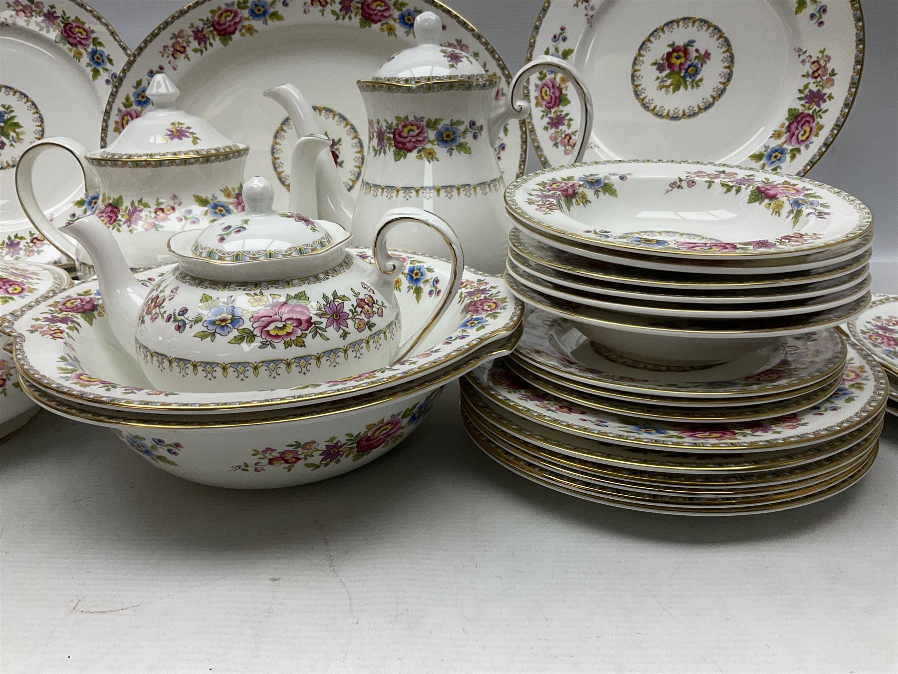 Extensive Royal Grafton Malvern pattern tea and dinner wares, comprising twelve dinner plates, six smaller plates, coffee pot, two teapots, two cake plates, eight teacups and ten saucers, six coffee cups and six saucers, two open sucriers, twin handled lidded sucrier, jug, lidded mustard pot and condiment jar, lidded tureen, two circular twin handled vegetable tureens, sauce boat and stand, oval and circular serving plates, salt and pepper shakers, breakfast cup and two saucers, further large cup and saucer, eighteen tea plates of various shapes, six side plates, six cereal bowls and six further bowls, shell dish and dish of square form, fork and knife, together with a hallmarked silver condiment spoon