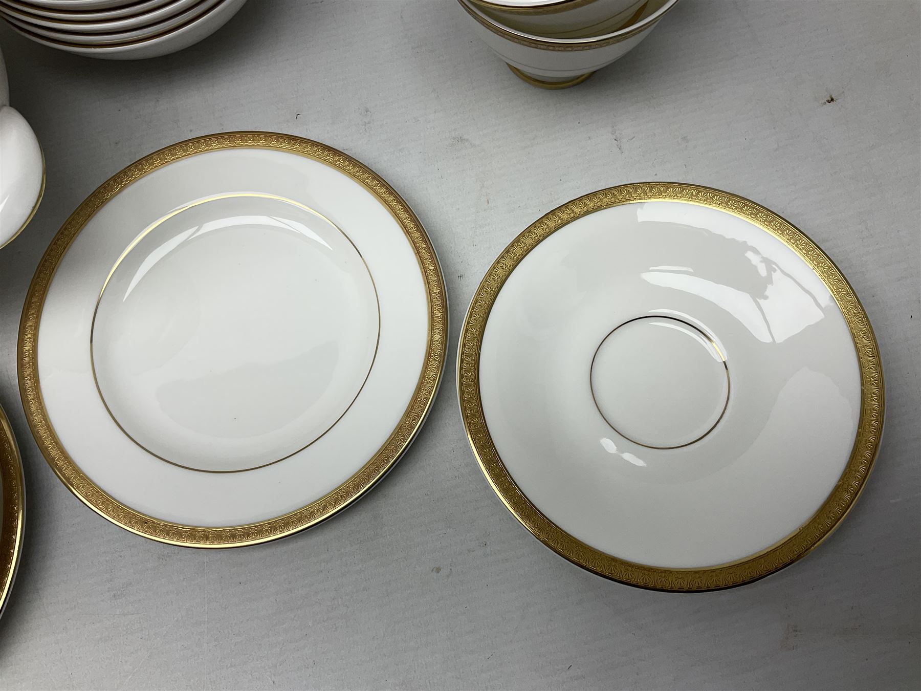 Royal Doulton Royal Gold pattern tea and dinner service for eight, comprising dinner plates, side plates, tea plates, soup bowls, sauce boat and saucer, dessert bowls, coffee cans and saucers, teacups and saucers and two lidded tureens