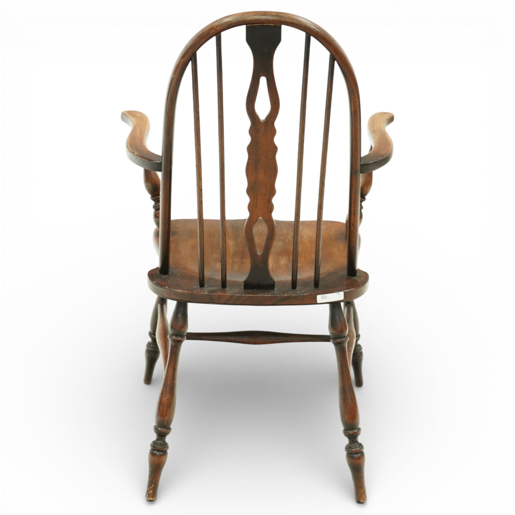 Early 20th century Windsor armchair, the arched hoop back enclosing a pierced and shaped splat flanked by turned spindles, above a shaped elm seat and outswept arms on turned supports, raised on turned legs united by an H stretcher