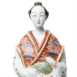 Large Japanese Imari porcelain figure, modelled as a Bijin, wearing a long kimono decorated with apple blossom and leafy branches on a white ground, with gilt detailing, possibly Edo period, H63cm