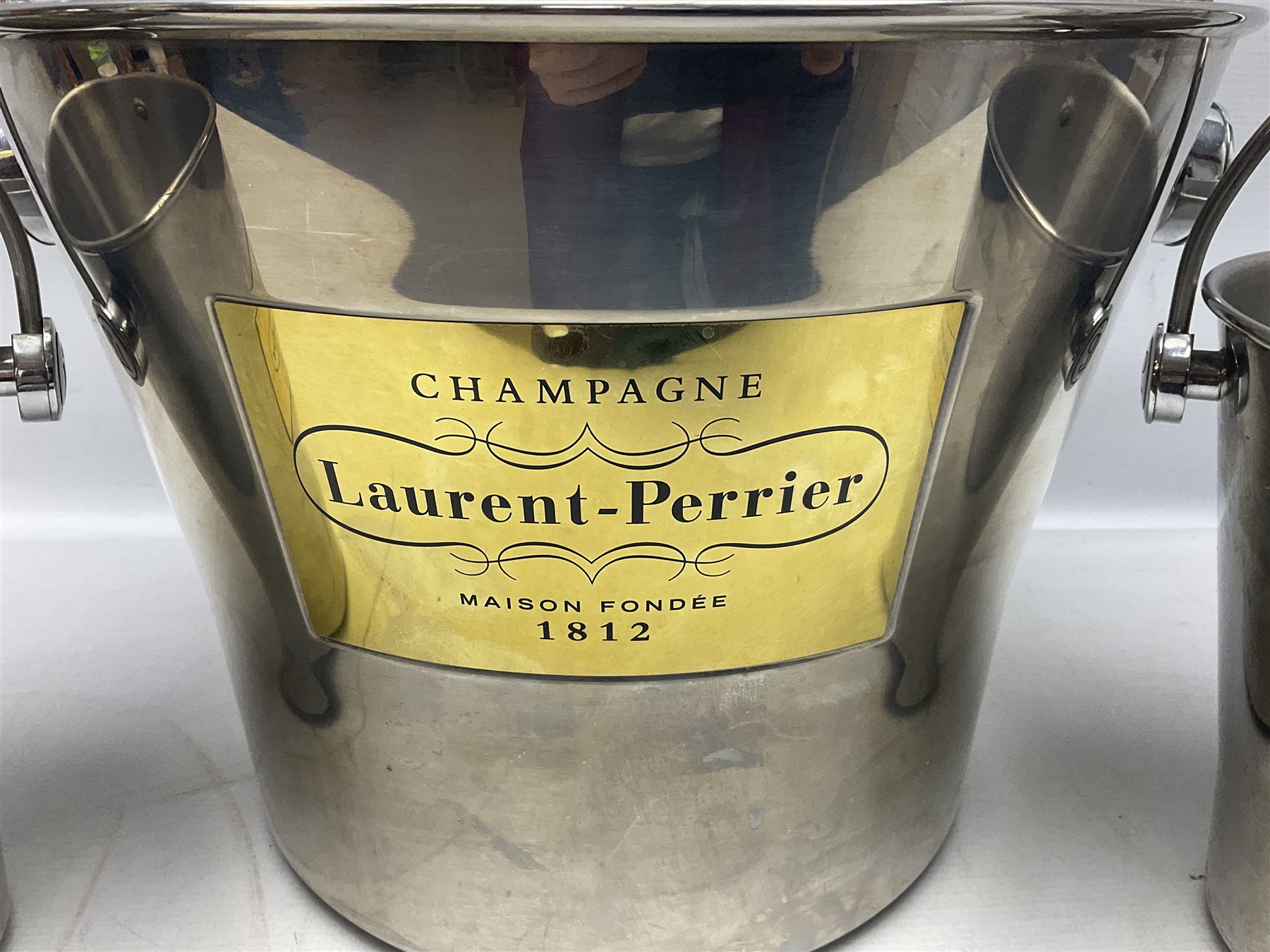 Stainless steel Laurent-Perrier champagne bucket, with engraved brass plaque and grip to swing handle, together with two matching smaller, largest D38cm (3)