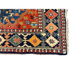 Persian blue ground rug, field decorated with four pole medallions with surrounding repeating bird motifs, coral spandrels with flowerheads, guarded border decorated with repeating geometric lozenges