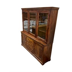 Large hardwood display wall unit, the upper section fitted with three glazed doors enclosing six shelves, the lower section fitted with four central drawers flanked by two panelled cupboards