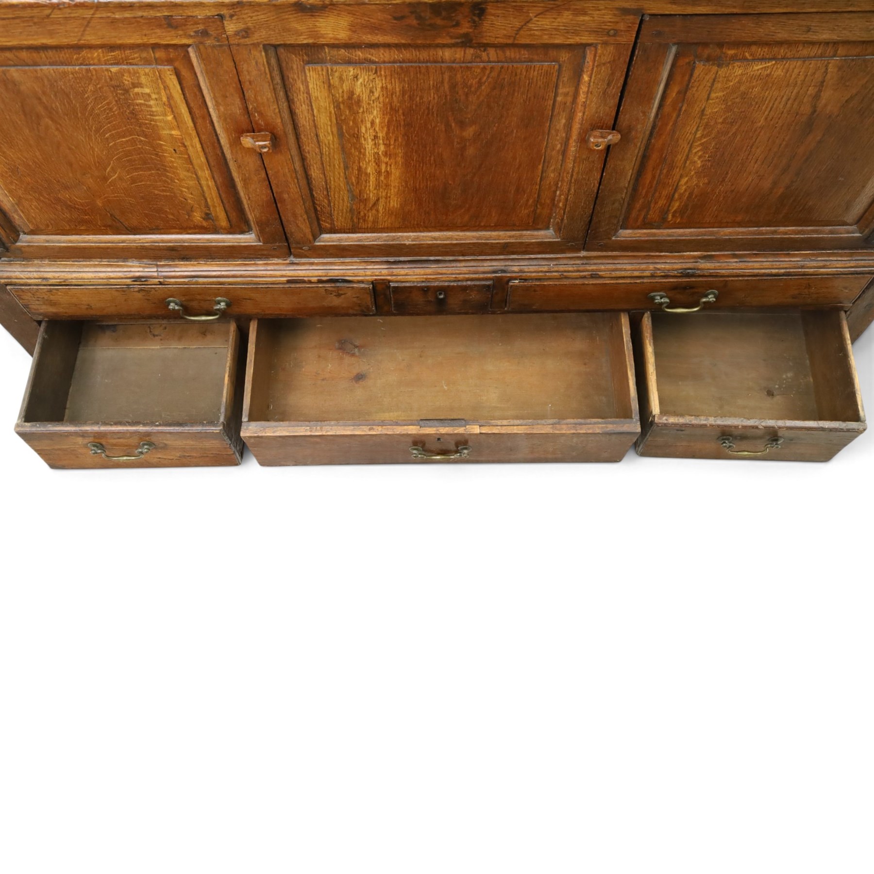 18th century oak hall cupboard, rectangular top with moulded edge, over two panelled hutch-cupboards, the base fitted with six assorted drawers, on large bracket feet
