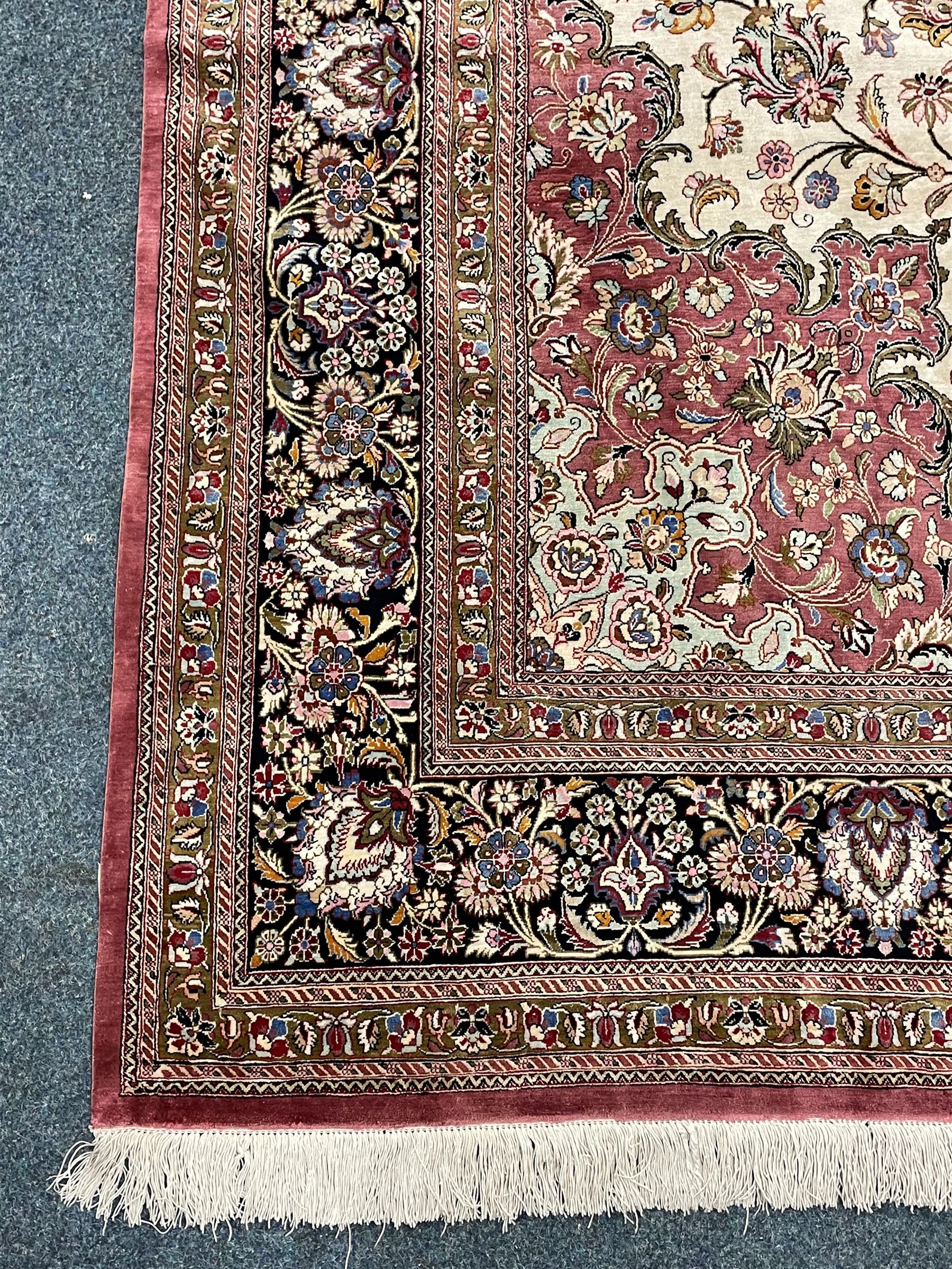 Finely knotted Persian Qom silk rug, overall pink ground with ivory field, the field with central cusped medallion profusely decorated with interlacing foliate and stylised flower heads, multiple band boarder, the main band decorated with a series of stylised motifs and trailing foliage, the outer guard with signature panel 