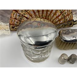 Silver clothes brush, mirror, glass dressing table jar and thimble, all hallmarked, together with a souvenir fan depicting scene after Goya, and two silver plated thimbles, 