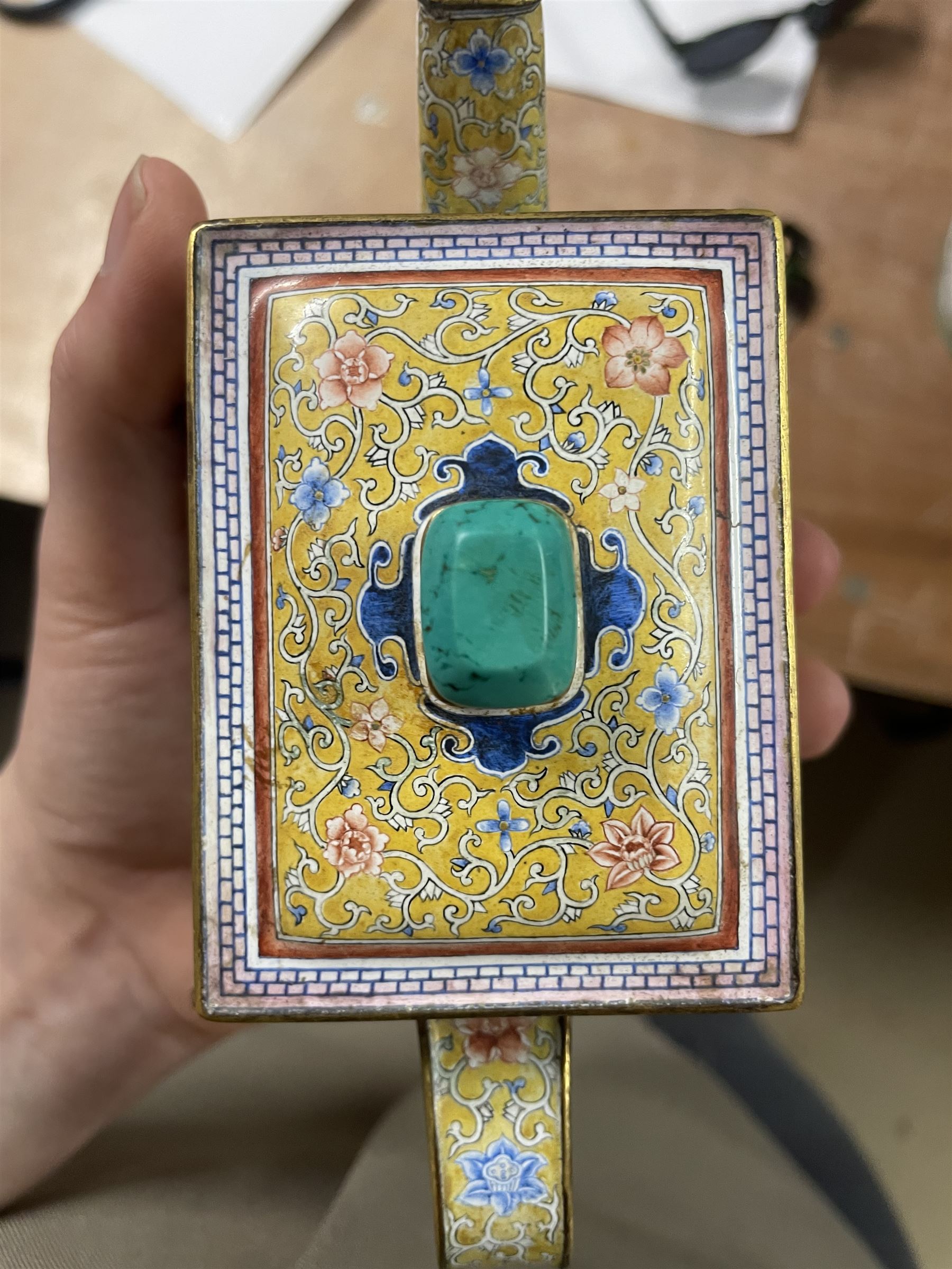 Chinese Qianlong enamel bombé shaped teapot, decorated with scenes of scholars examining a scroll and drinking on a yellow ground with various traditional floral and foliate motifs, the painted scene framed within trailing blue vine border, with Qianlong marks to base L15cm