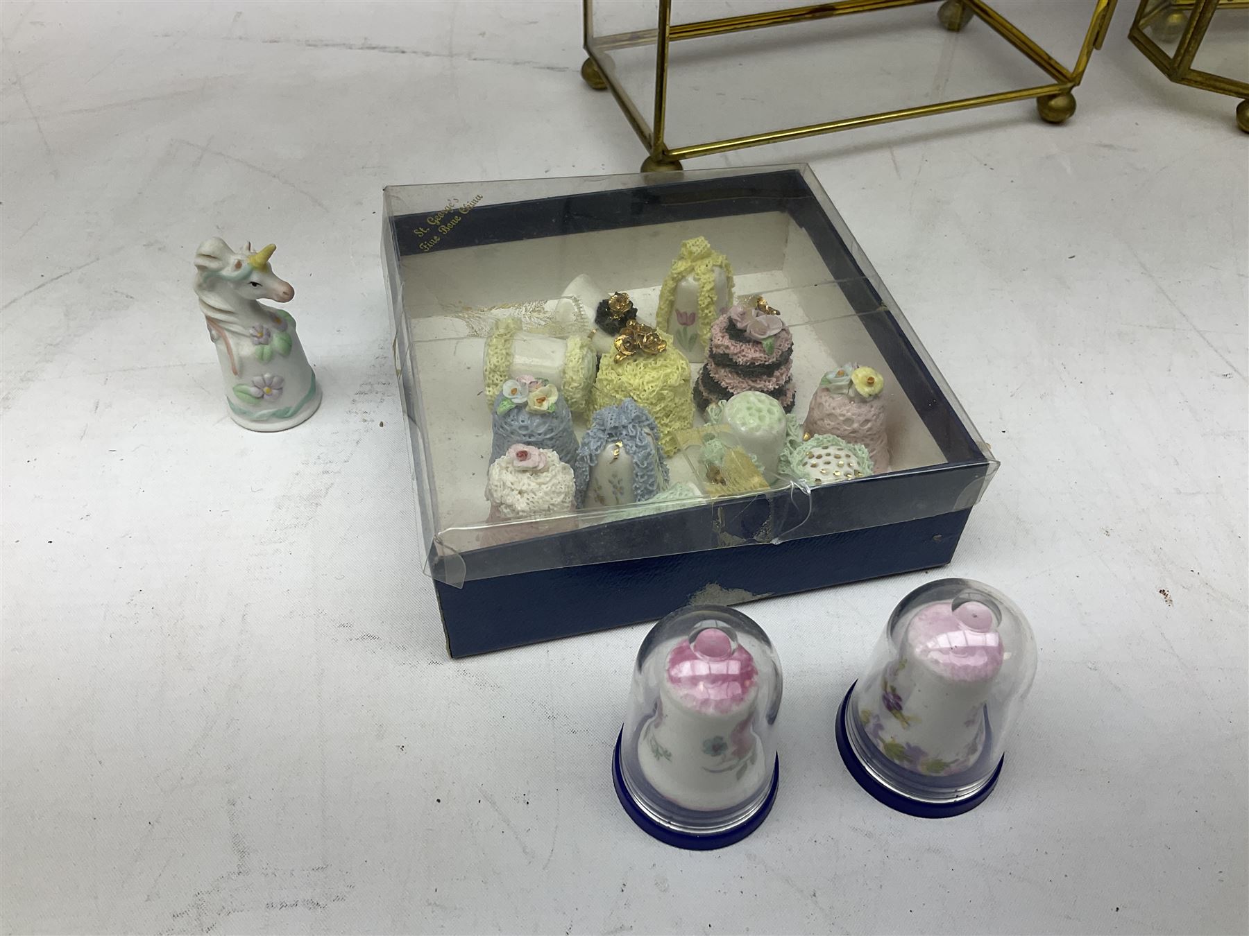 Quantity of thimbles to include twelve Irish Dresden lace examples, Royal Crown Derby, Spode, Portmeirion, Wedgwood, Royal Grafton etc, together with three display cases, many with certificates