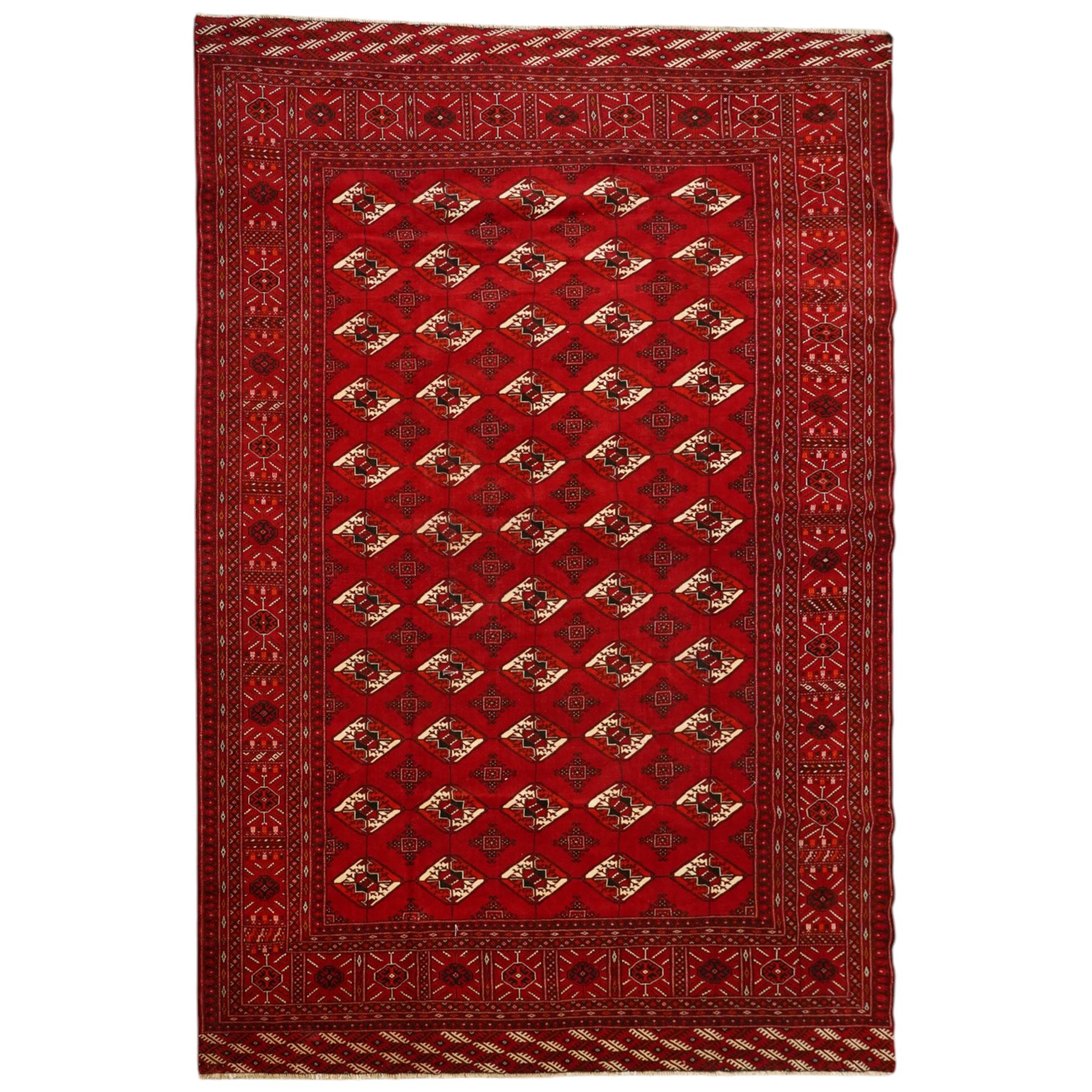 Turkmen hand-knotted carpet, deep crimson ground field, with an all-over lattice of repeating diamond guls, each enclosing angular cruiform motifs, and stylized tribal devices, interspersed with smaller geometric ornaments, main border decorated with repeating geometric motifs and stylized tribal elements, flanked by narrow guard stripes, with cotton fringe ends 
