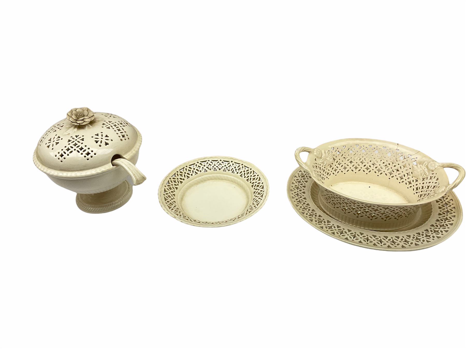 20th century Leeds creamware, comprising chestnut basket and stand, small tureen and cover, ladle, and associated stand, candlestick with stem modelled as a dolphin, teapot, tureen and cover in the form of a melon with fixed stand, and toast rack (toast rack a/f), each with impressed mark beneath. 