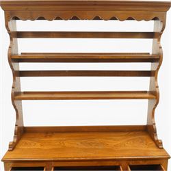 Georgian design elm dresser with plate rack, the two-tier rack with shaped frieze and hooks, over a rectangular top, fitted with three yew-wood banded drawers, shaped apron over turned supports united by undertier