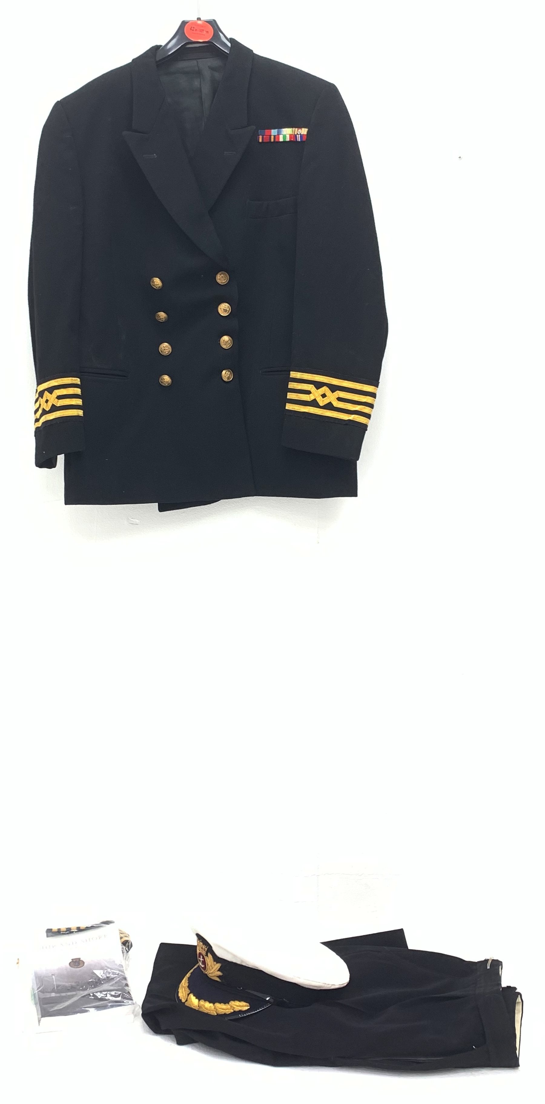 Merchant Navy captain's uniform with WW2 medal ribbons and peaked cap, epaulettes, spare cuff braiding, quantity of buttons and metal badges and two books of maritime interest