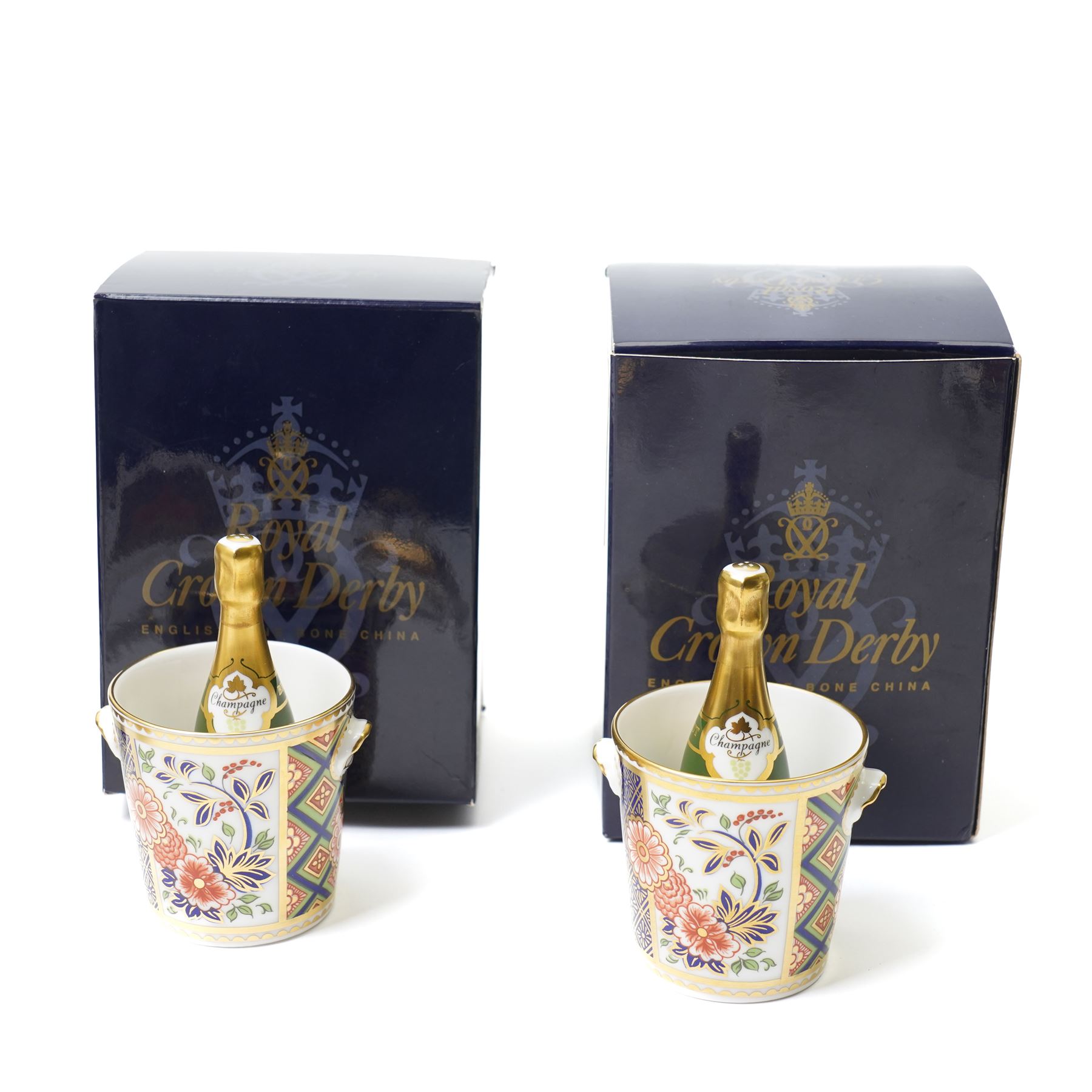 Collection of Royal Crown Derby miniature wares in Imari type patterns, comprising two champagne buckets with miniature champagne, milk churn, kettle, watering can, lawn roller, wheelbarrow, bench and kettle, five with boxes (10)