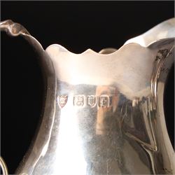 Georgian design silver cream jug with crimped rim and engraved with a crest London 1901 Maker Haseler Bros. and two smaller silver cream jugs (3)