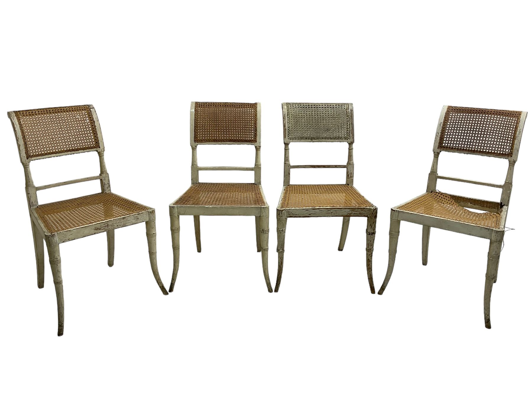 Collection of Regency dining chairs - set of four Regency painted beech dining chairs, with cane seat and back, on collar turned supports with splayed feet (W46cm, H84cm); a pair of Regency ebonised dining chairs (W47cm, H77cm); and a single Regency dining chair, the cresting rail painted with floral cornucopias and central putto vignette, X-frame back over cane seat, on collar turned front supports painted with foliage (W46cm, H84cm) (7)