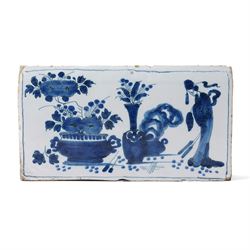 18th century English Delft flower brick, painted with a Chinese figure stood beside antiqu...