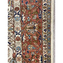 Large Persian carpet, pale ground with peach ground central medallion, the field decorated with interlacing foliate and stylised flower heads, light blue spandrels with stylised plant motifs, repeating guarded border 