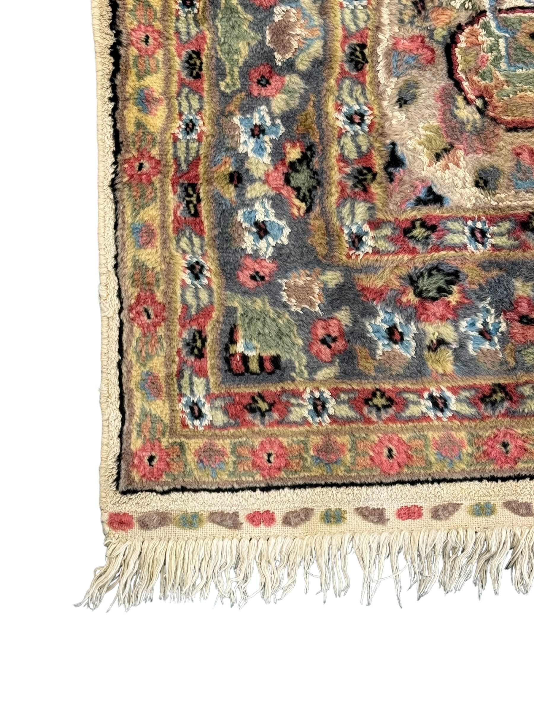 Persian design ivory ground rug, overall floral design with shaped central medallion, the main border decorated with trailing flower head pattern, within guard stipes 