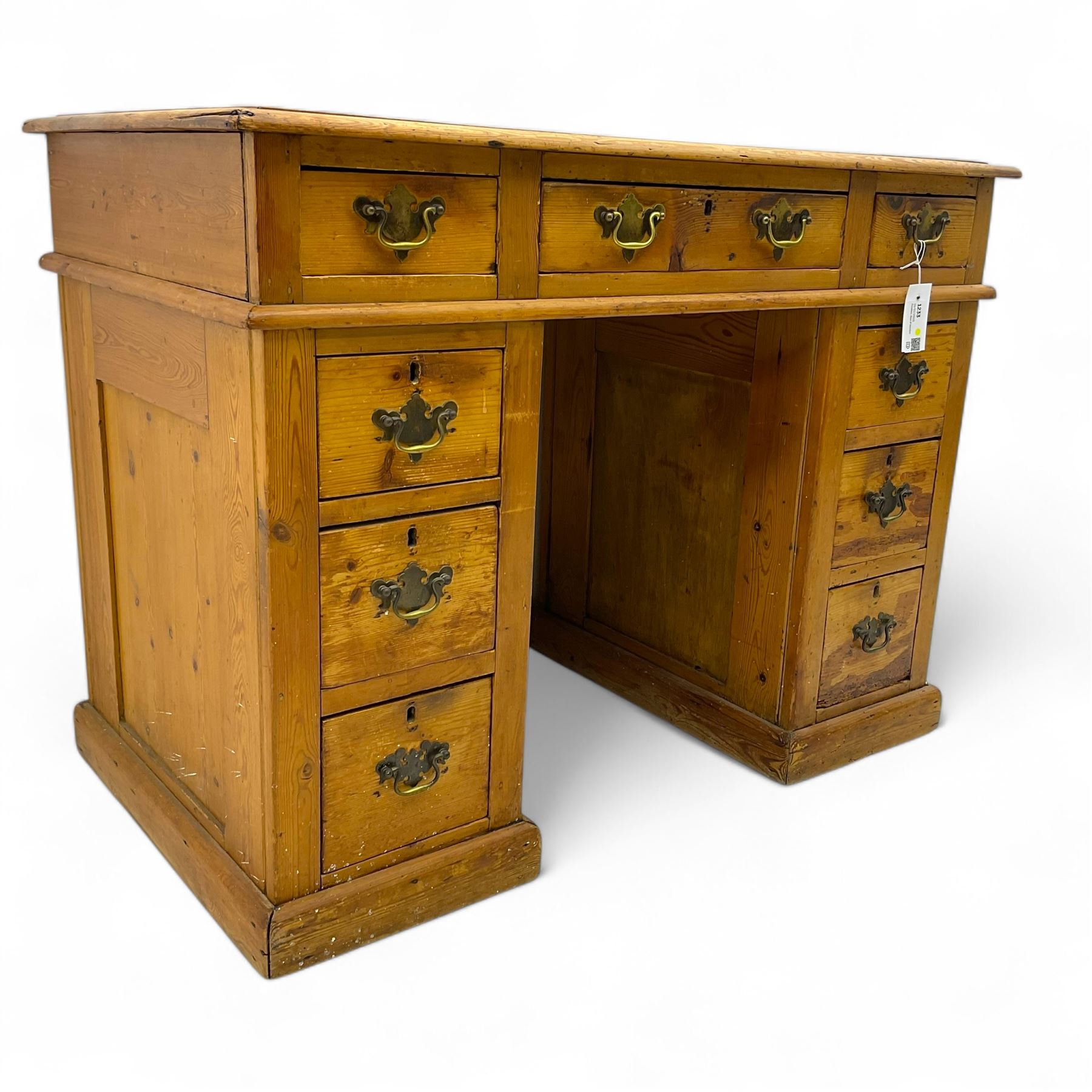 Rustic pine twin pedestal desk, rectangular green leather inset top above a central frieze drawer flanked by two short drawers, each pedestal featuring three graduated drawers, raised on a plinth base