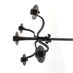 Wrought hand forged iron candle stand, four scrolled branches and central vertical branch with sconces, tapered column on four shaped and out splayed supports