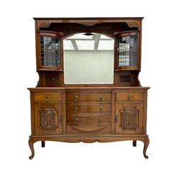 Late Victorian walnut mirror back sideboard or dresser, the raised back fitted with two curved and lead glazed cabinets, central arched bevelled mirror, the sideboard with break bowfront, fitted with six drawers and two cupboards, the cupboard doors panelled and carved with scrolls, shell and plant motifs, shaped apron with cabriole feet
