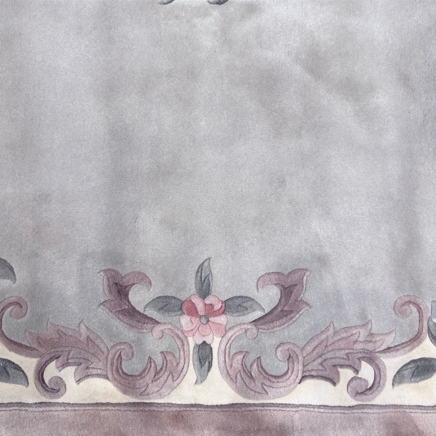 Chinese Aubusson-style jade green wool rug, with a floral medallion and floral corner sprays with a scrolling acanthus and ribbon border in tones of teal, cream, pink, mauve, and cotton fringe ends