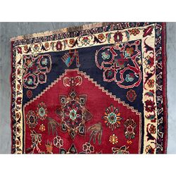 Persian rug, red ground field decorated with stylised flower heads and bird motifs, floral scrolling border