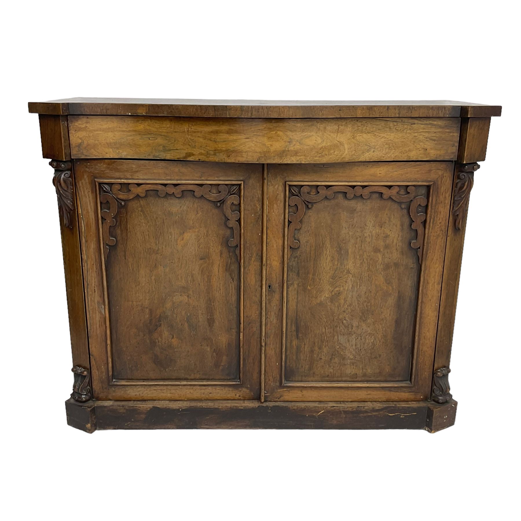 William IV rosewood serpentine chiffonier, fitted with frieze drawer over two panelled cupboard doors with applied C-scroll decoration, flanked by canted uprights with moulded foliate corbels